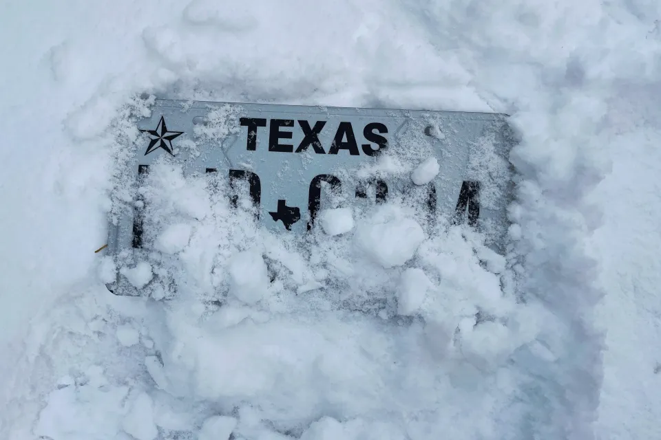 Texas license plate almost entirely covered by snow